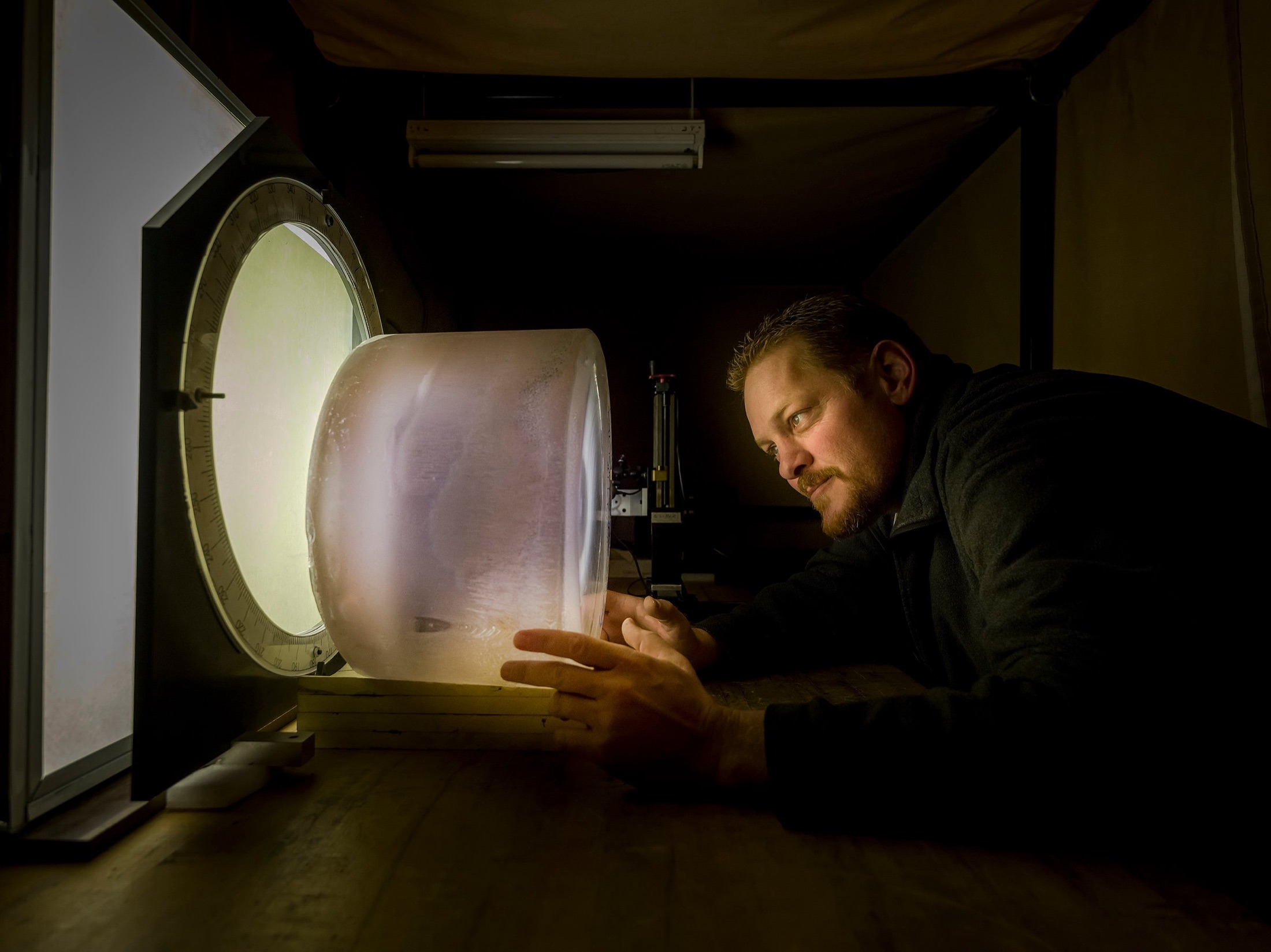 A grown crystal boule examined against a light table